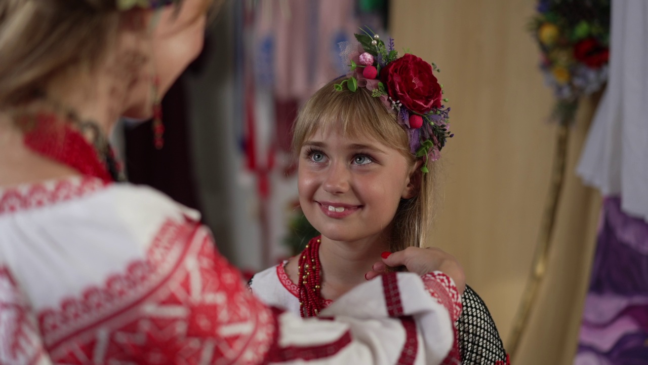 可爱的乌克兰孩子微笑的肖像看着女人辫子长头发在慢动作。漂亮的女儿，赞赏的母亲照顾孩子。投篮的肩膀。视频素材