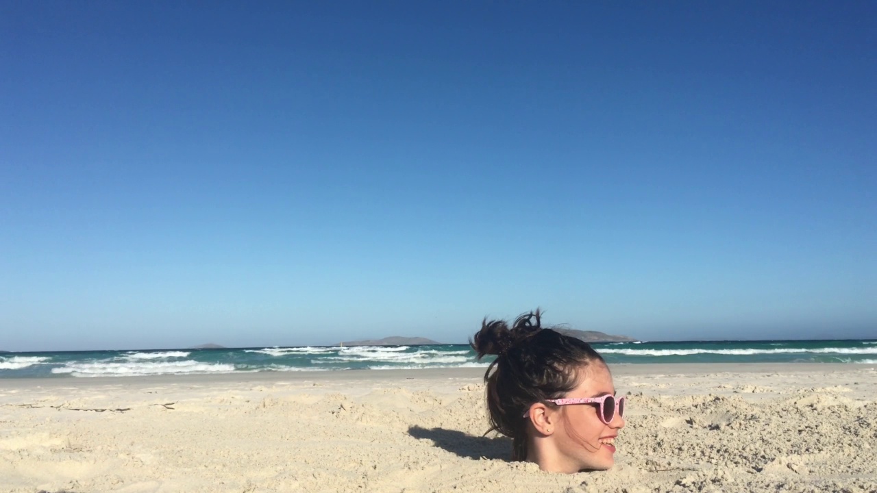 小女孩在海滩上把头埋在沙子里视频下载