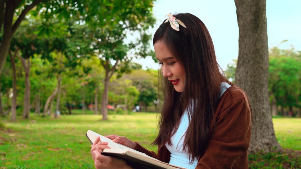 一个女人在公园里看书。视频素材