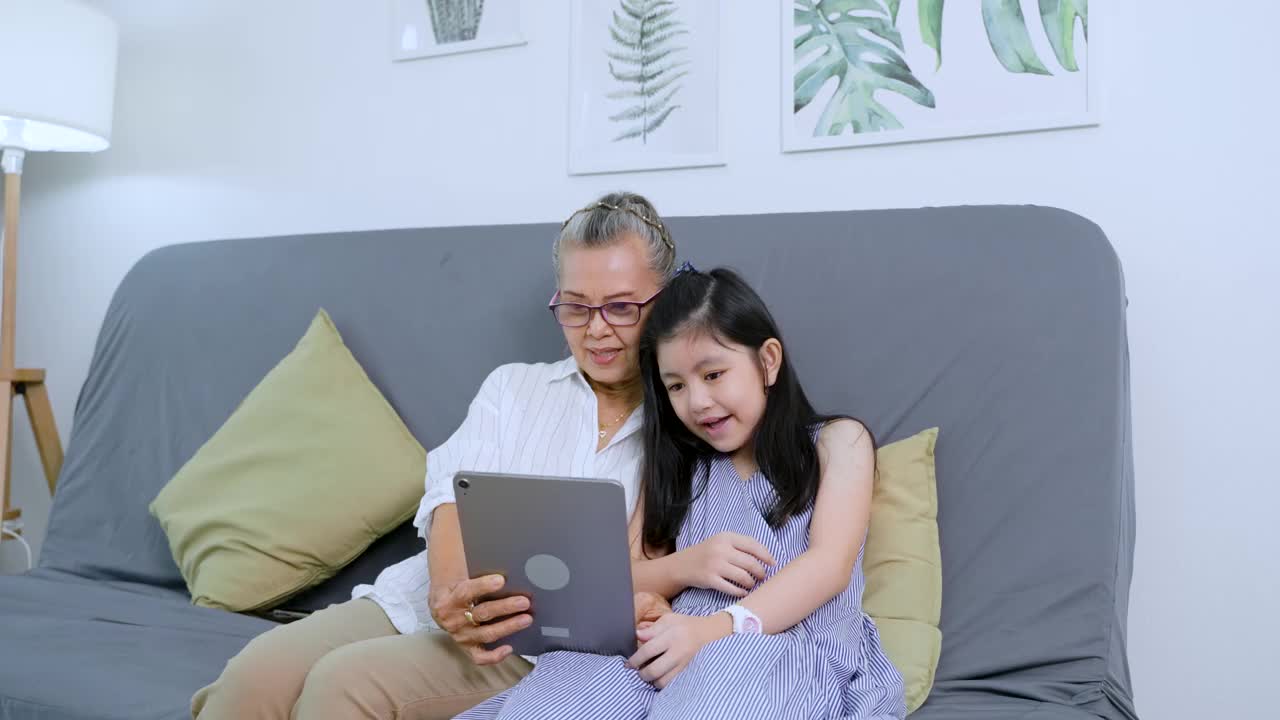 祖父母和孙子在家里用平板电脑进行视频通话视频下载