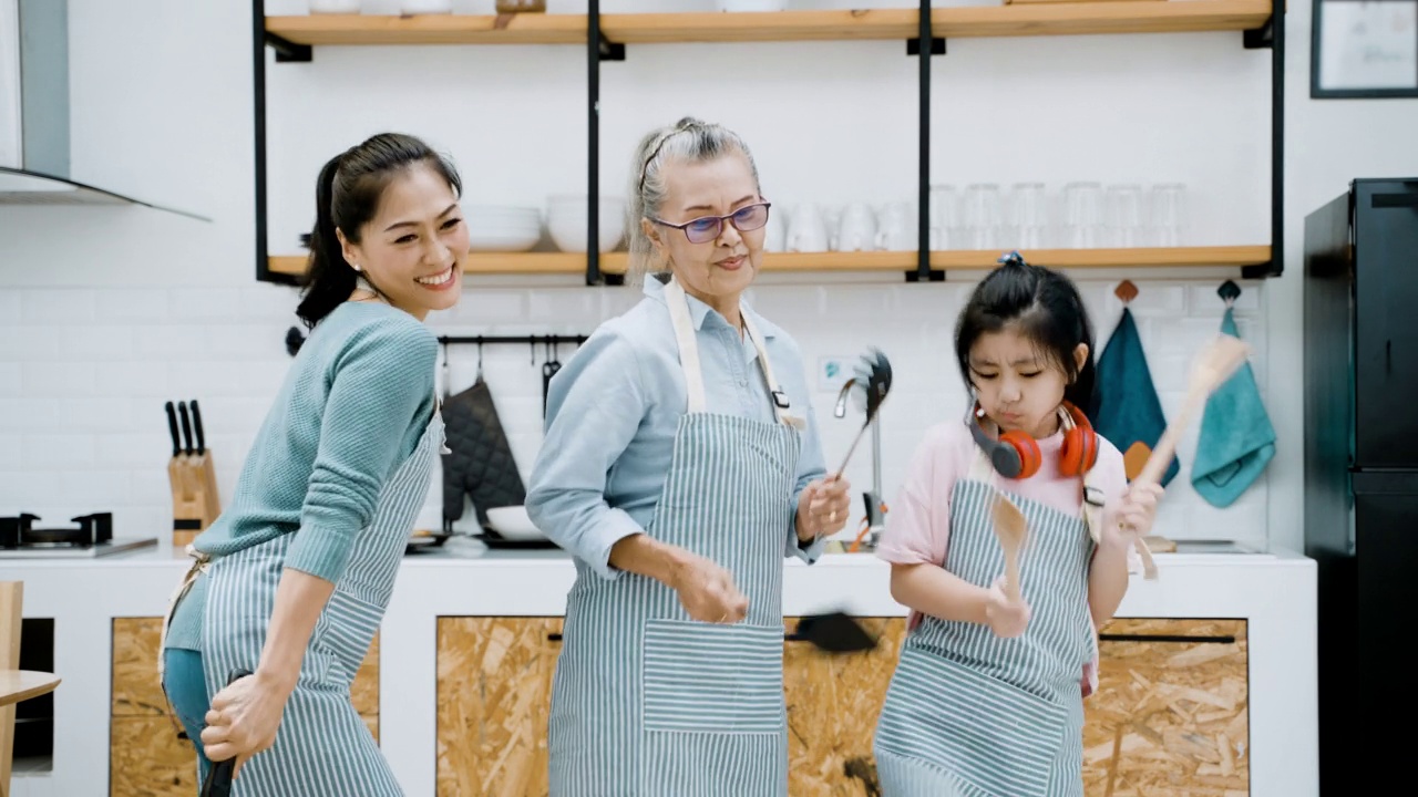欢快的亚洲家庭一边在厨房里准备食物一边跳舞视频下载