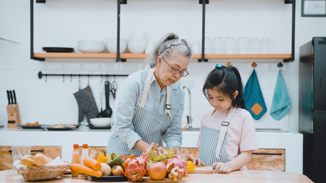 亚洲老人和孙女在厨房准备食物视频下载