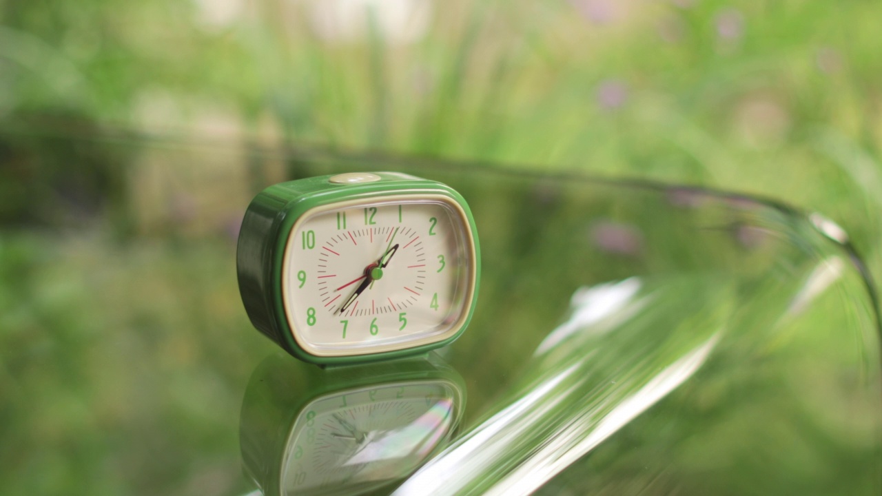 玻璃桌上的绿色复古闹钟视频素材