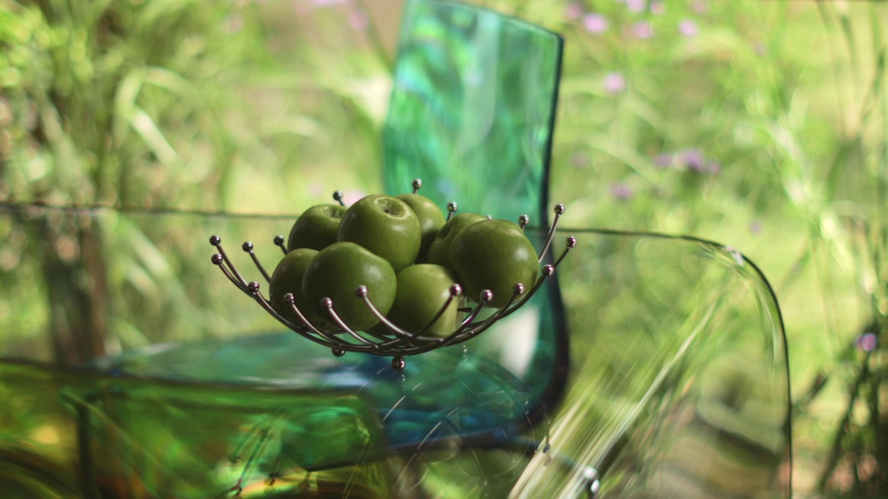 绿色的苹果在现代水果碗在透明的玻璃桌视频素材