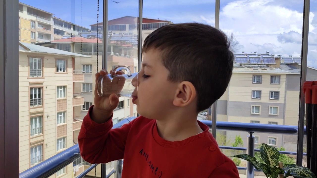 男孩在阳台上喝水视频下载
