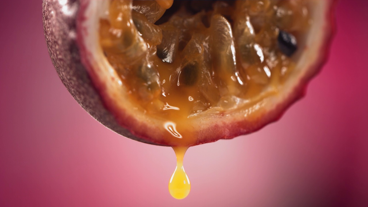 从一半马拉库亚流动的百香果马拉库亚果汁的慢动作微距镜头视频下载