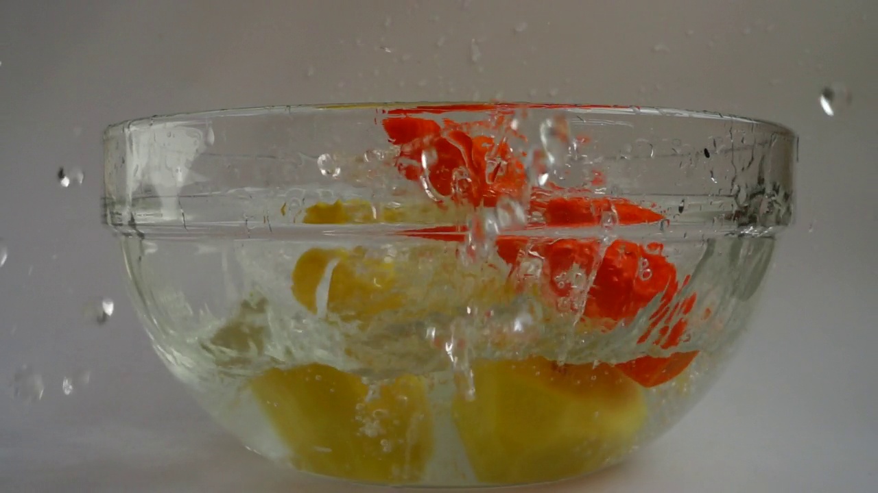 落汤蔬菜集，土豆，胡萝卜和洋葱到一个玻璃碗的水。缓慢的运动。视频素材