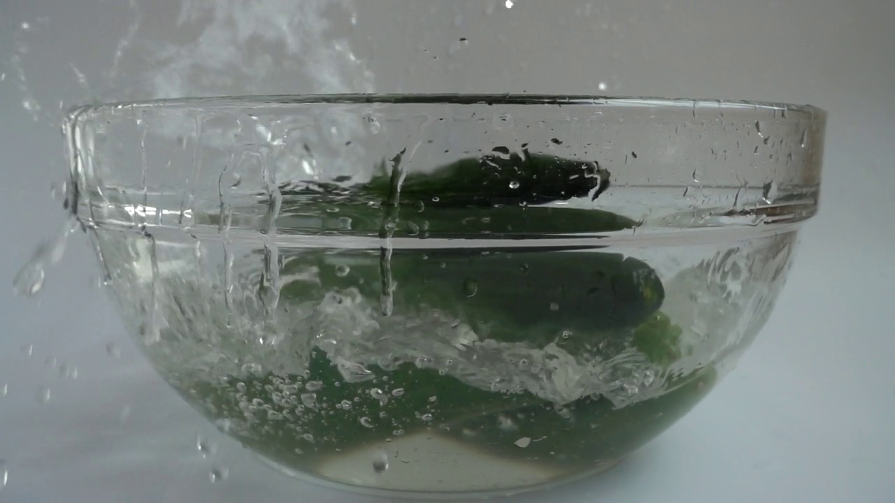 落在玻璃碗里的黄瓜。缓慢的运动。视频素材