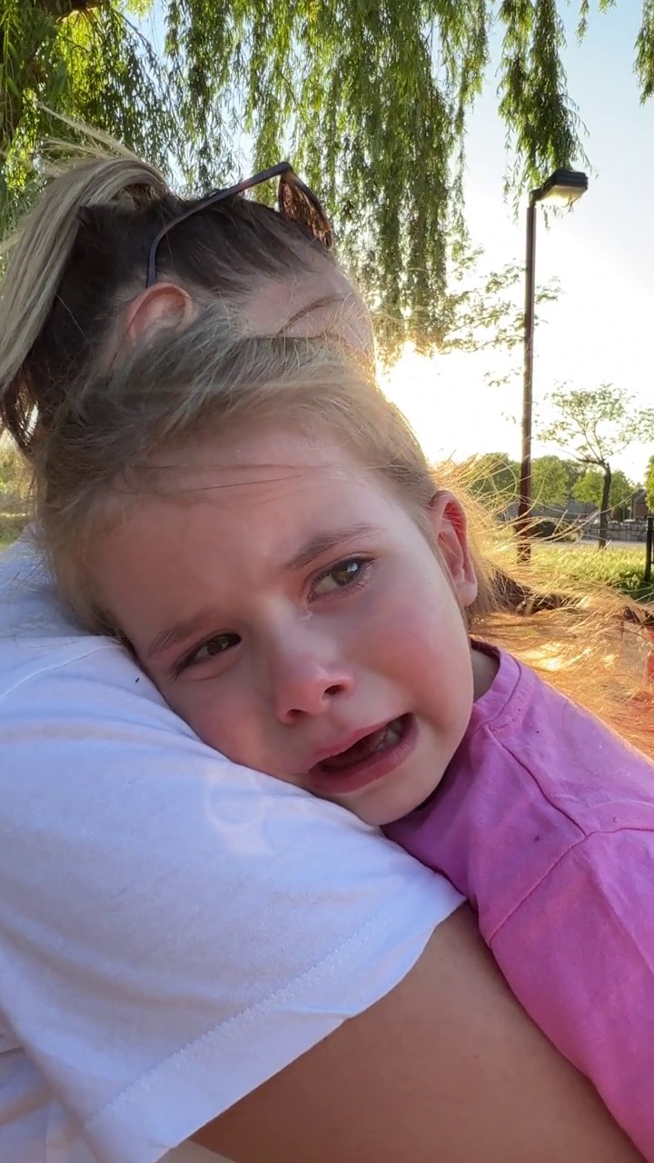 蹒跚学步的女孩，哭泣，而她的母亲安慰她视频素材