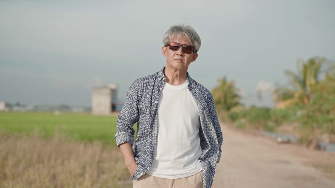 稻田旁的亚洲华人活跃老人肖像，态度冷淡视频素材