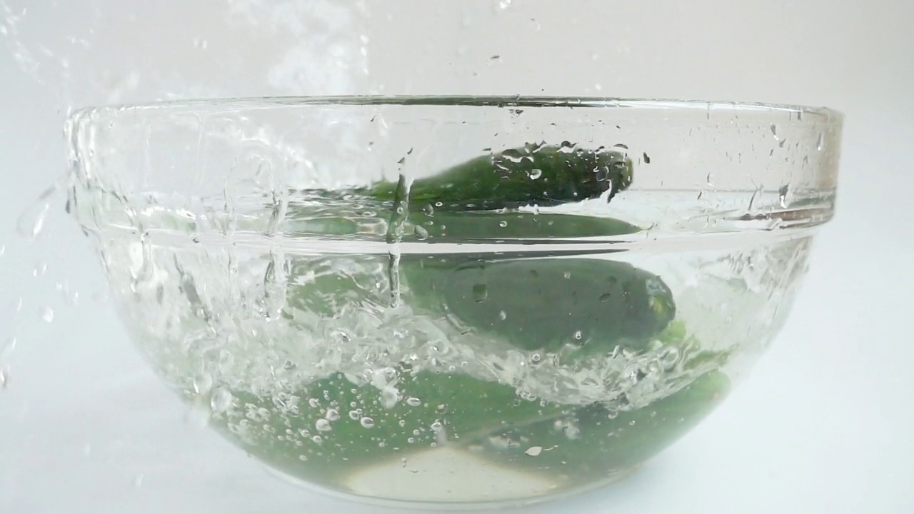落在玻璃碗里的黄瓜。缓慢的运动。视频素材