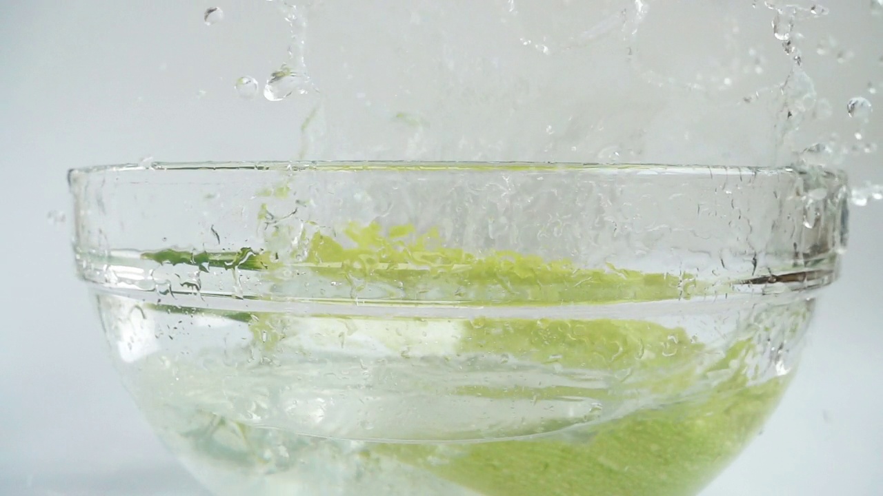 落在盛着水的玻璃碗里的西葫芦。缓慢的运动。视频素材