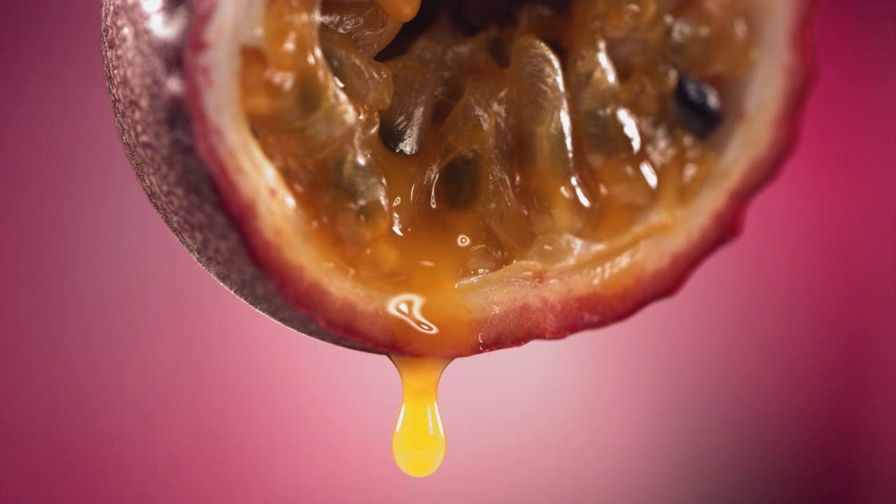 从腰斩马拉库亚流动的百香果马拉库亚果汁的慢动作微距镜头视频下载