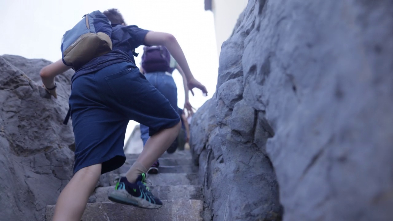 一家人在Cefalu镇和大海之间的岩石上徒步旅行视频下载