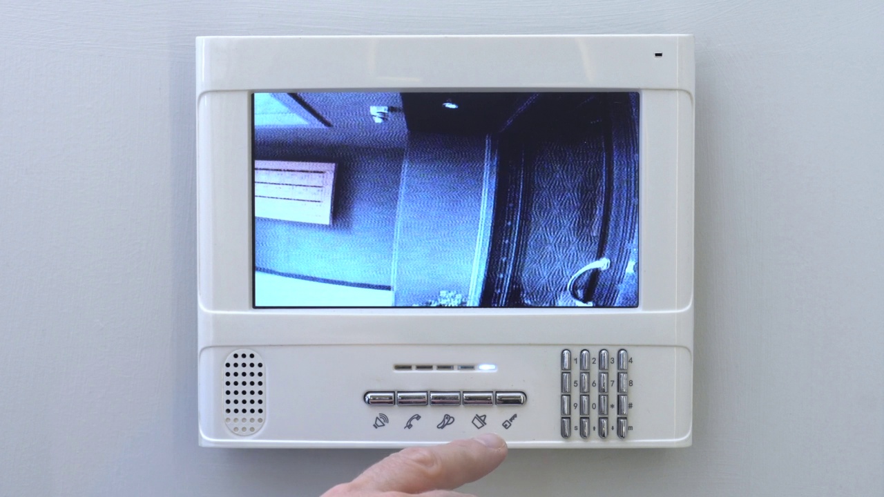一只使用公寓可视对讲机系统的手。视频素材