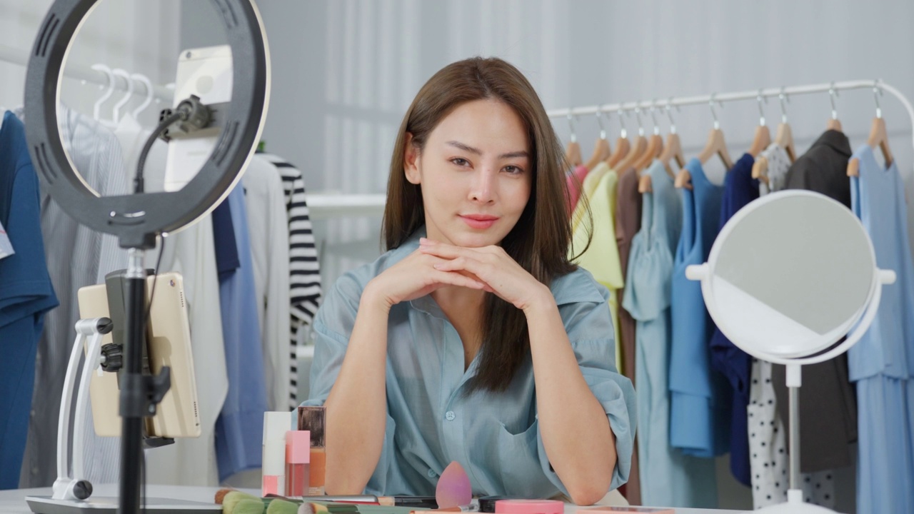 亞洲女人的肖像在網上賣衣服和看著相機。有吸引力的美麗的年輕女商人坐在桌子上自信和感覺快樂的金融業務在倉庫視頻下載