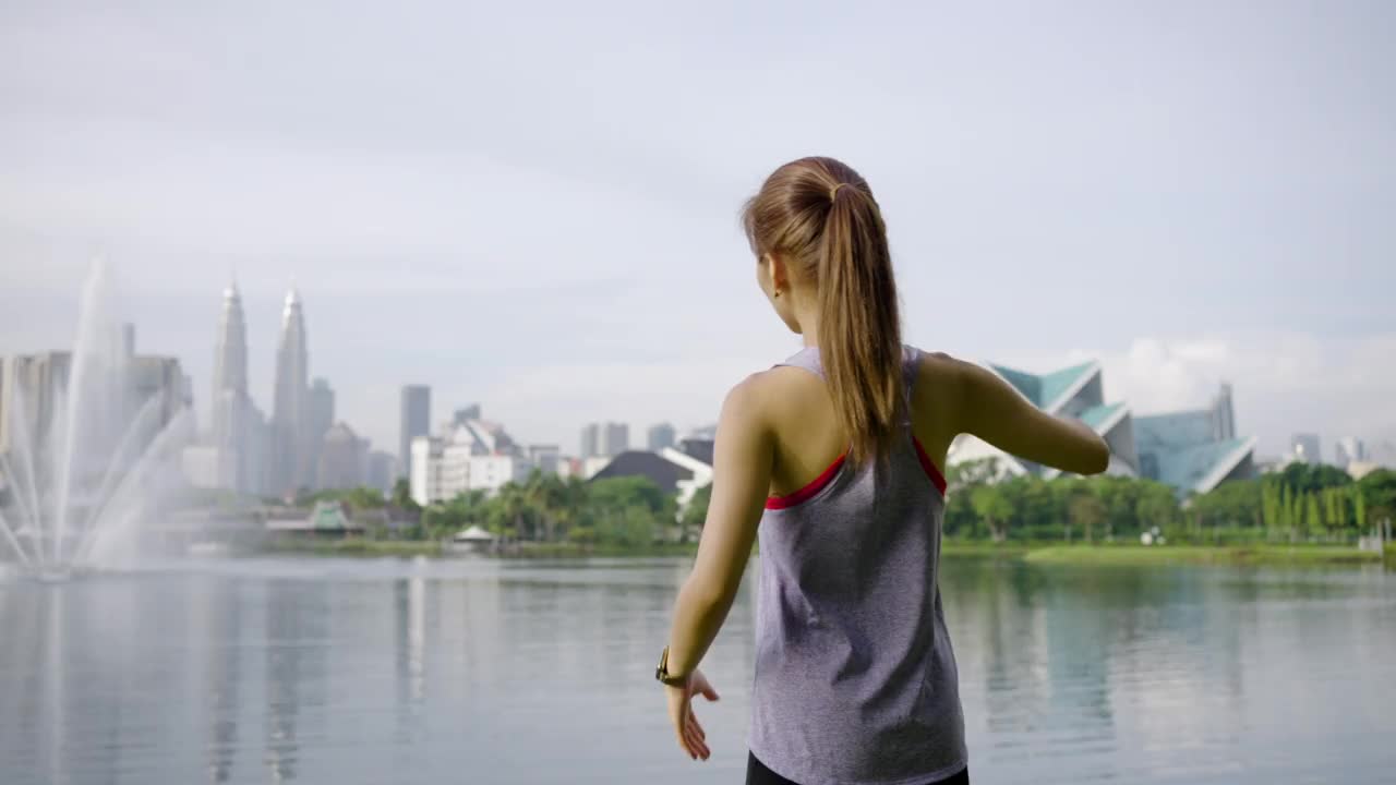 年轻的亚洲女子早上在公园伸展运动视频下载