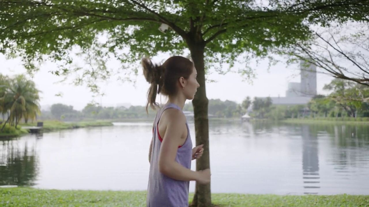 一位亚洲女性早上在公园慢跑视频下载