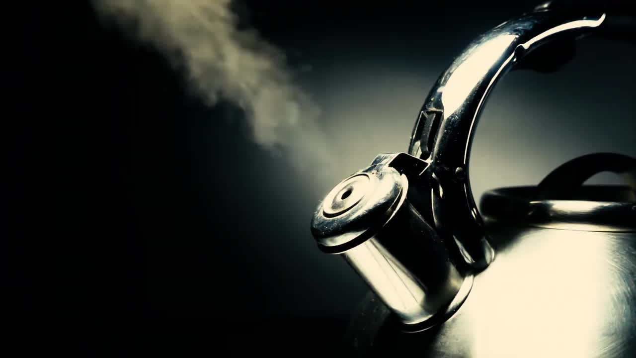 沸腾的钢银水壶与哨子蒸汽特写在黑色背景。4k原始慢动作视频60帧/秒。视频下载