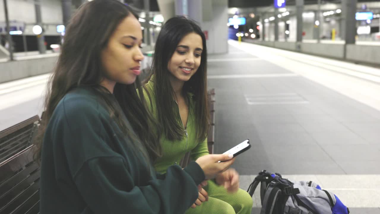 拿著手機在車站等車的女游客視頻素材