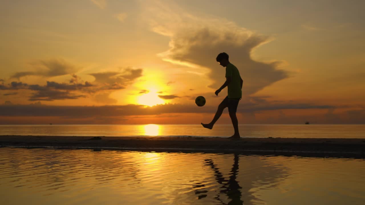一个人在沙滩上踢足球视频素材