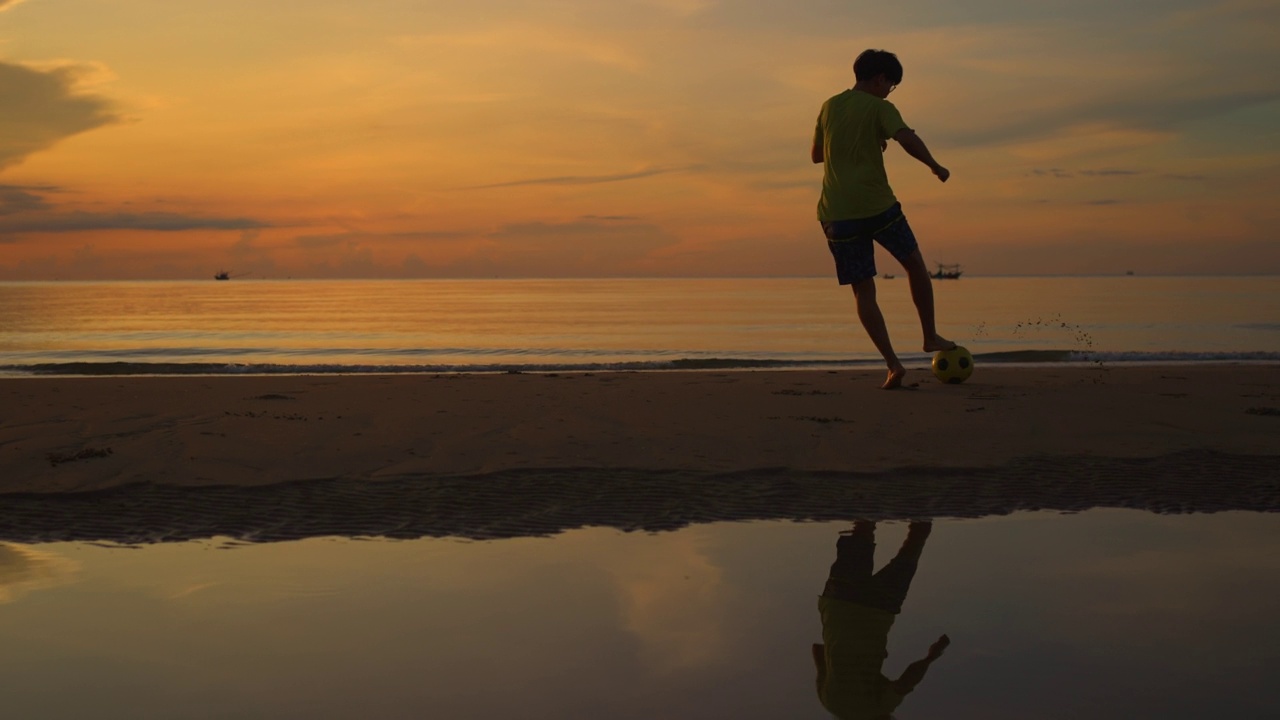 一个人在沙滩上踢足球视频素材