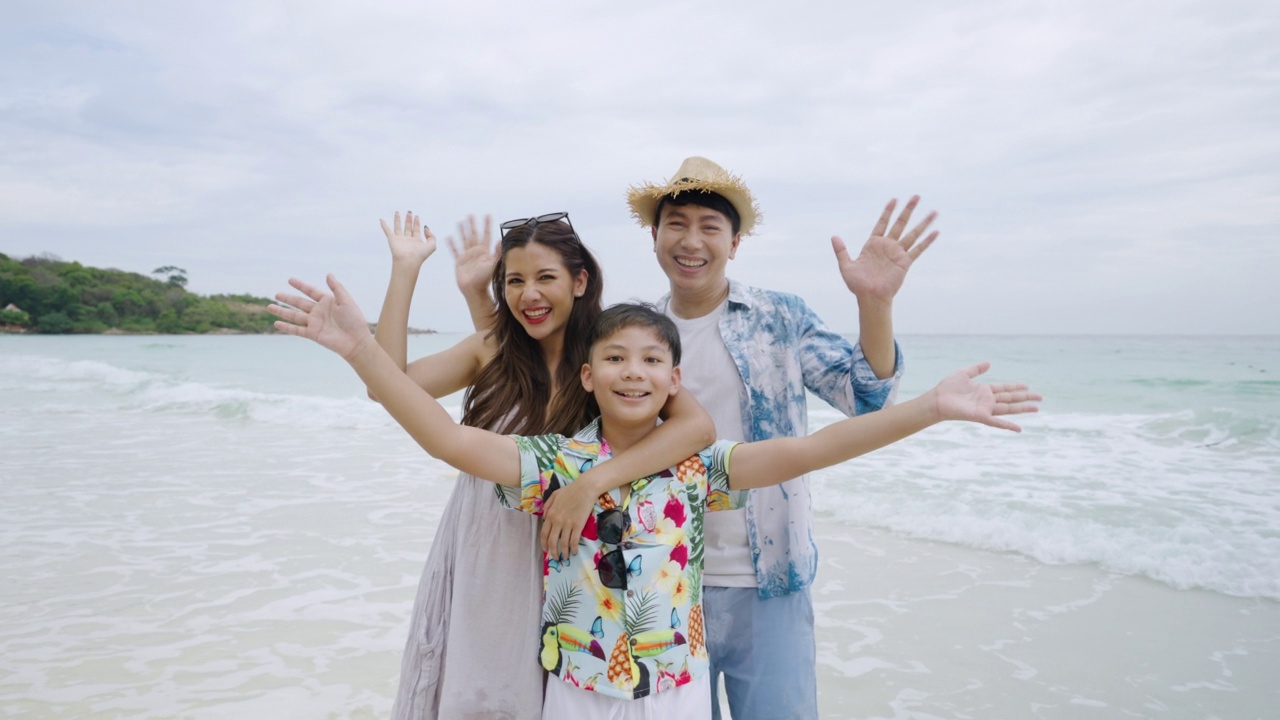 沙滩上的亚洲家庭看着相机视频下载