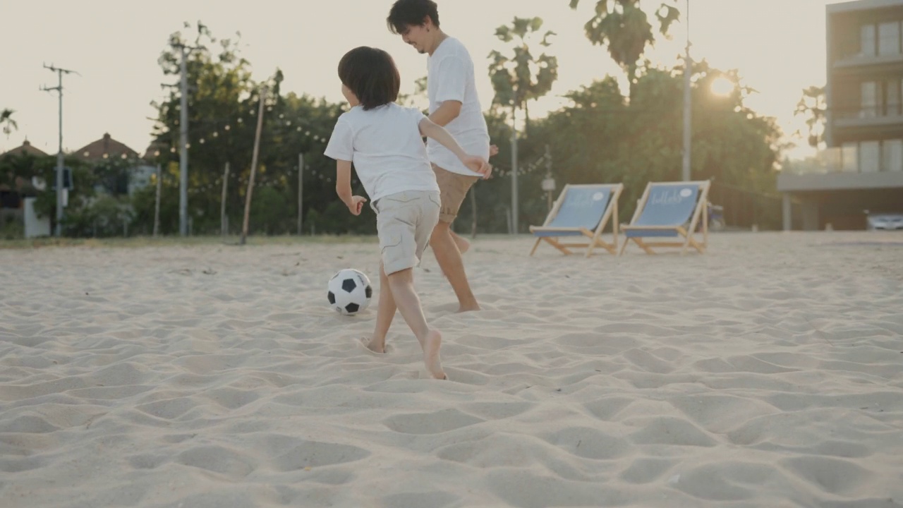 父亲在教儿子在海滩上踢足球视频下载