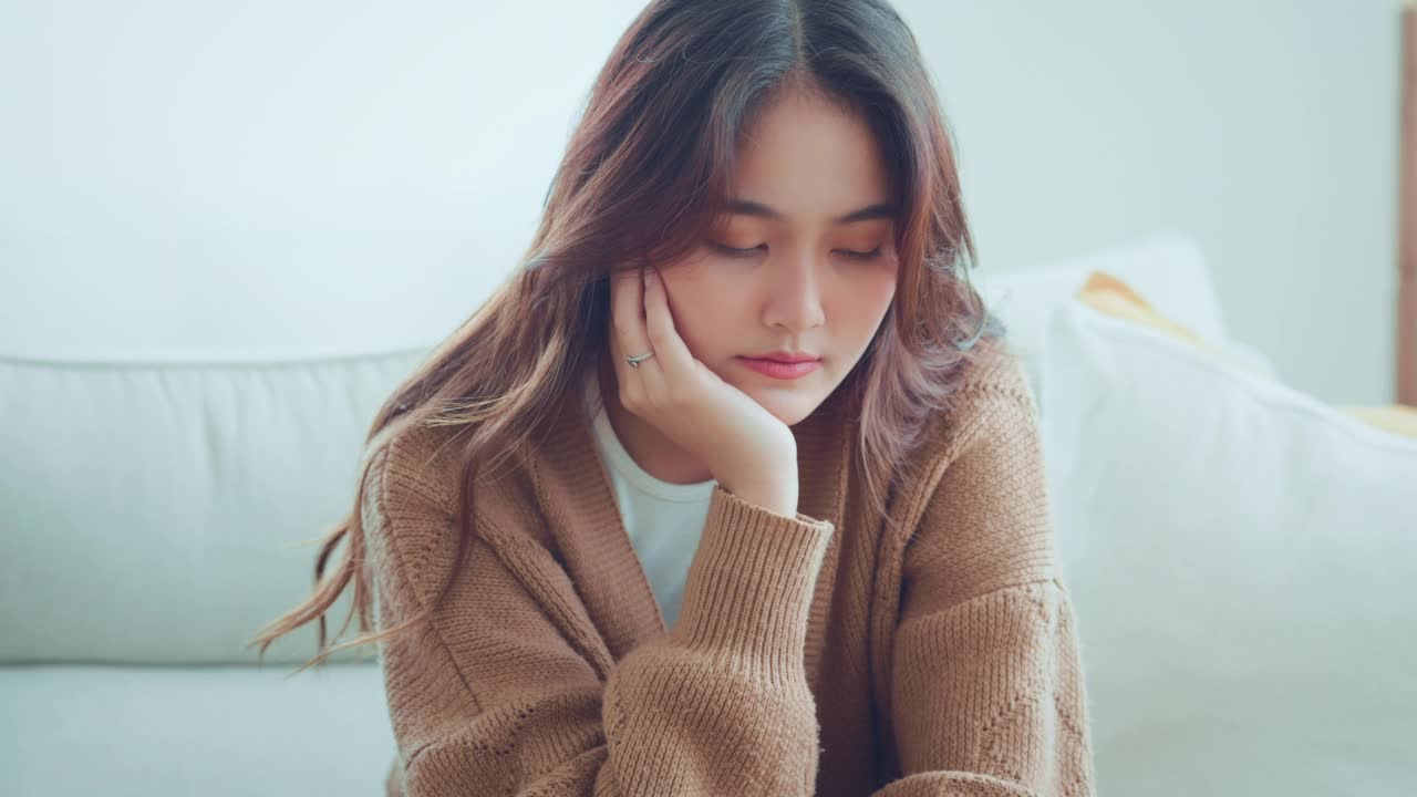 伤心疲惫的年轻亚洲妇女触摸前额头痛偏头痛或抑郁症，心烦沮丧的女孩困扰的问题感到压力。视频素材