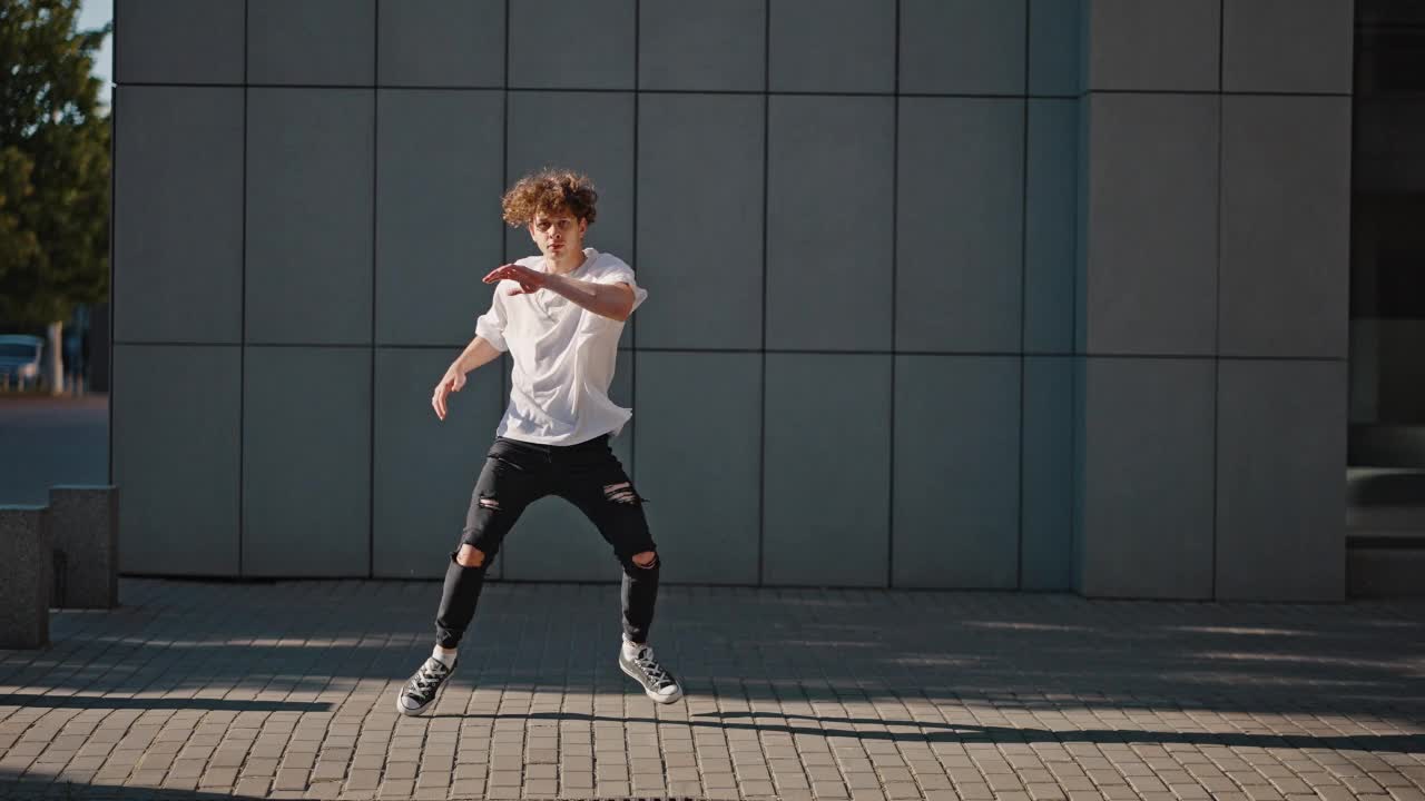 年轻的舞者在城市街道的人行道上表演快步舞视频下载