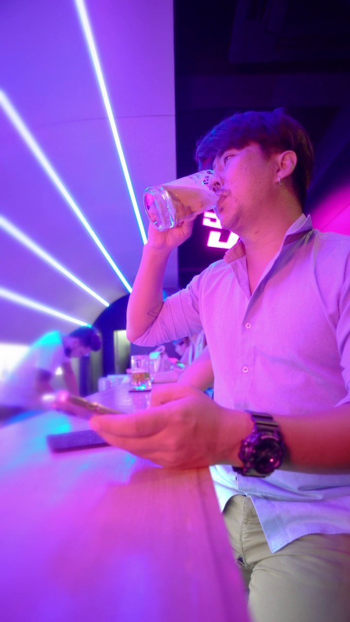 亚洲男人在夜总会喝啤酒-下班后视频素材