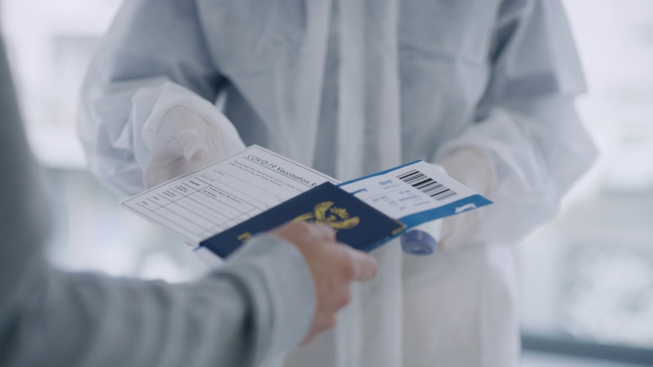 在新冠肺炎封鎖期間，一名旅客讓機場工作人員測量體溫。在新冠肺炎疫情期間，機場當局正在檢查旅客的體溫視頻素材