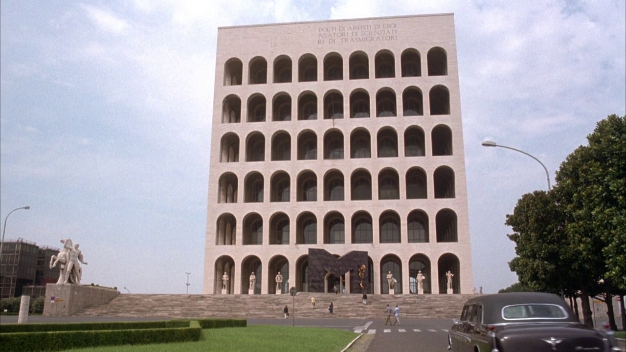罗马“文明宫殿”大楼的广角。见左边的骑马人像。汽车从摄像机后面驶入背景，停在建筑物前。又名“意大利文明的宫殿”，这座大理石六层的建筑视频下载