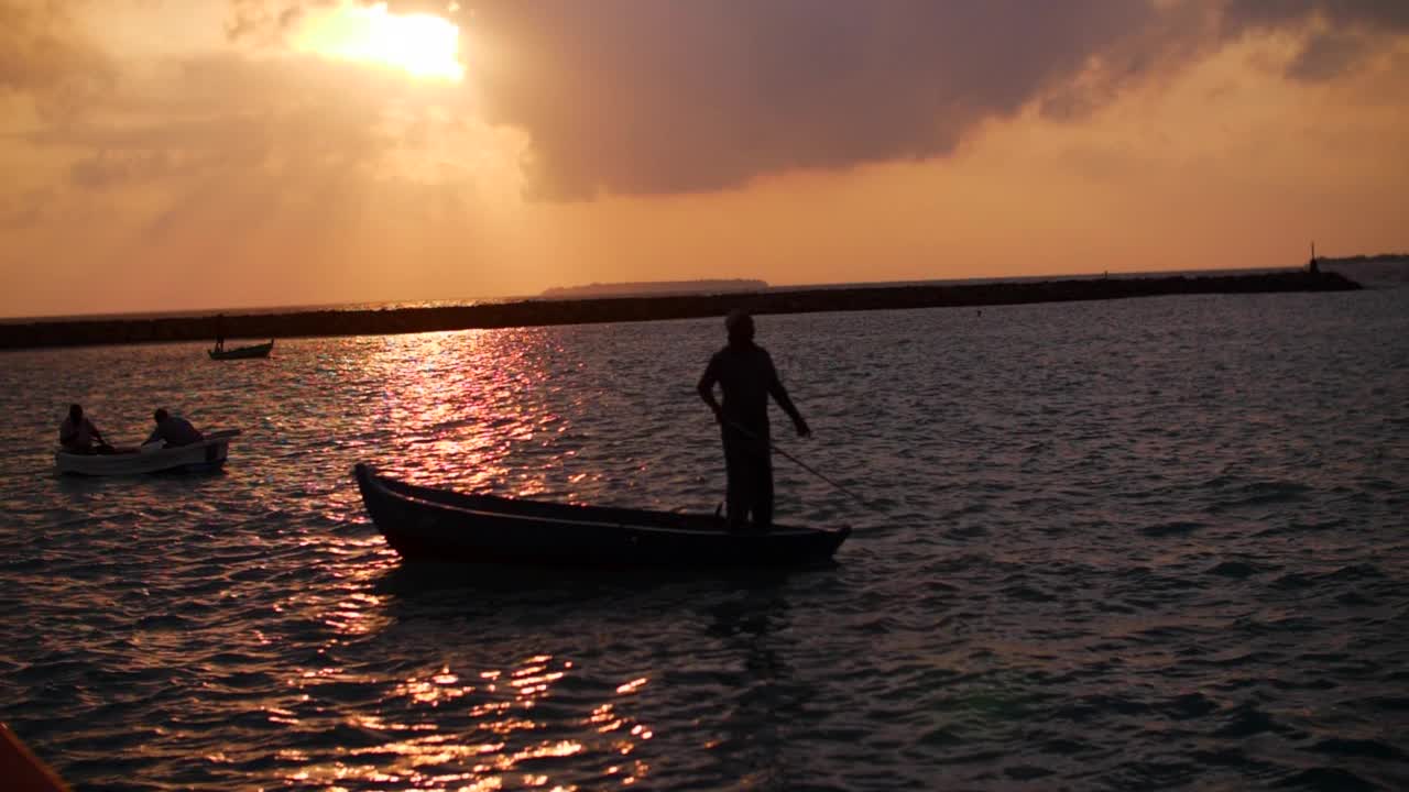 慢動作拍攝的人在船在波濤起伏的海洋在日落期間-大堡礁，澳大利亞視頻下載