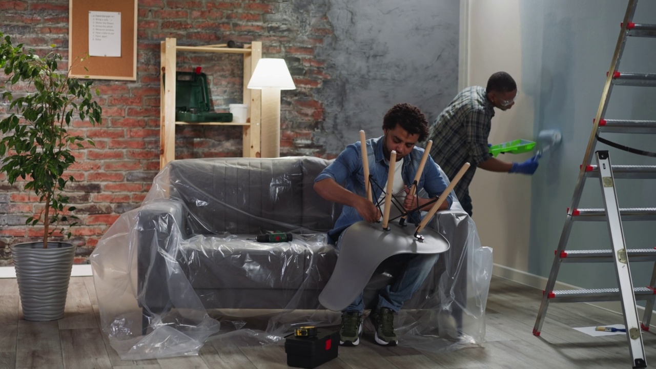 非洲裔美国人粉刷墙壁，兄弟组装椅子视频下载