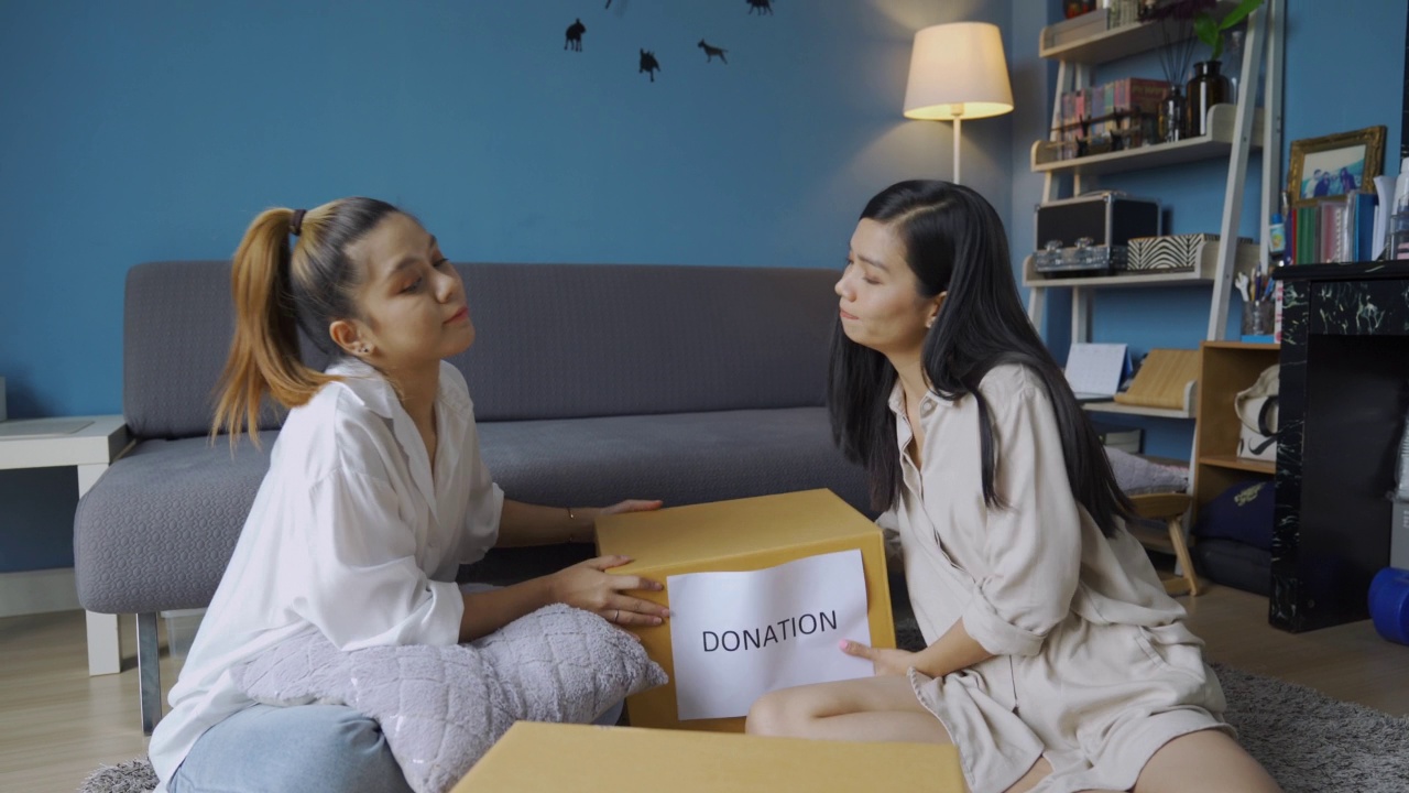 一名亚洲女子将衣物放入捐赠箱内视频素材
