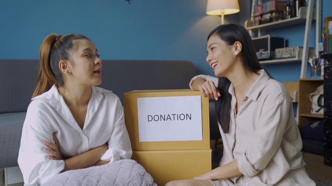 两位亚洲妇女保存衣物捐献的肖像视频素材
