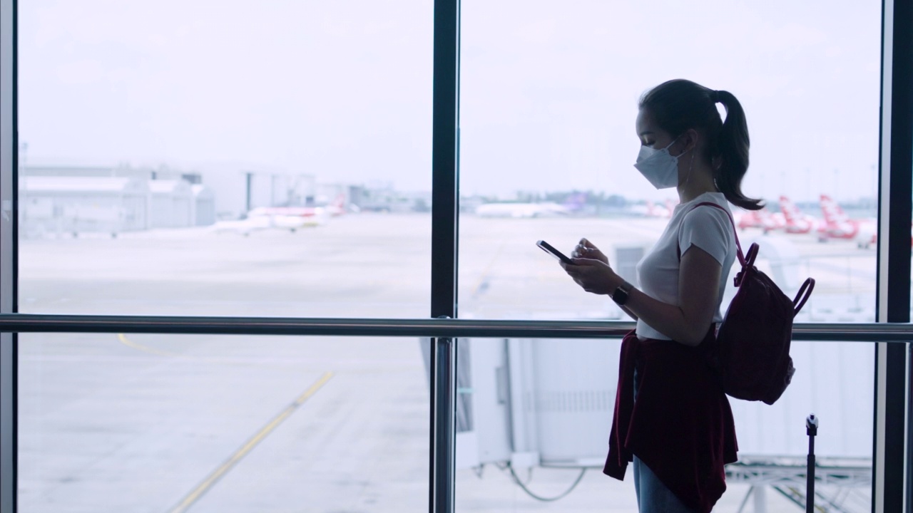 一位年轻的女游客带着行李在机场散步视频下载