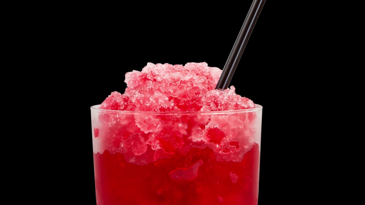 西班牙Granizado或红色Slushie饮料与天然果汁在黑色背景，特写。4 k的视频。水果刨冰在透明的玻璃。清爽的夏日饮品。咖啡厅、餐厅的横幅视频下载