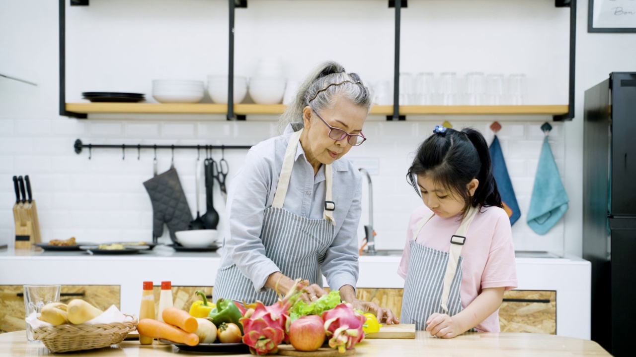 亚洲老人和孙女在厨房准备食物视频下载