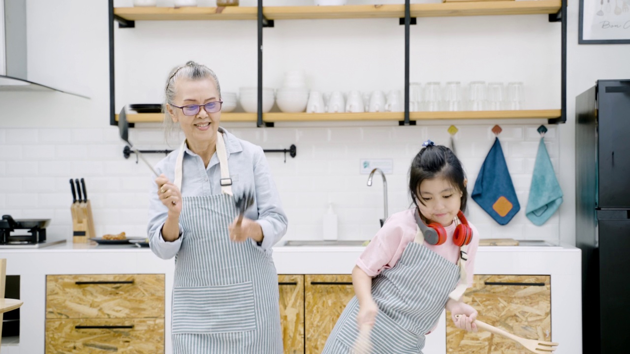 祖父母和孙子在厨房做饭时跳舞视频下载