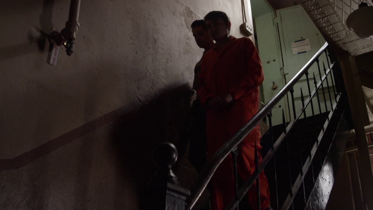 一名警衛護送一名囚犯走下樓梯視頻素材