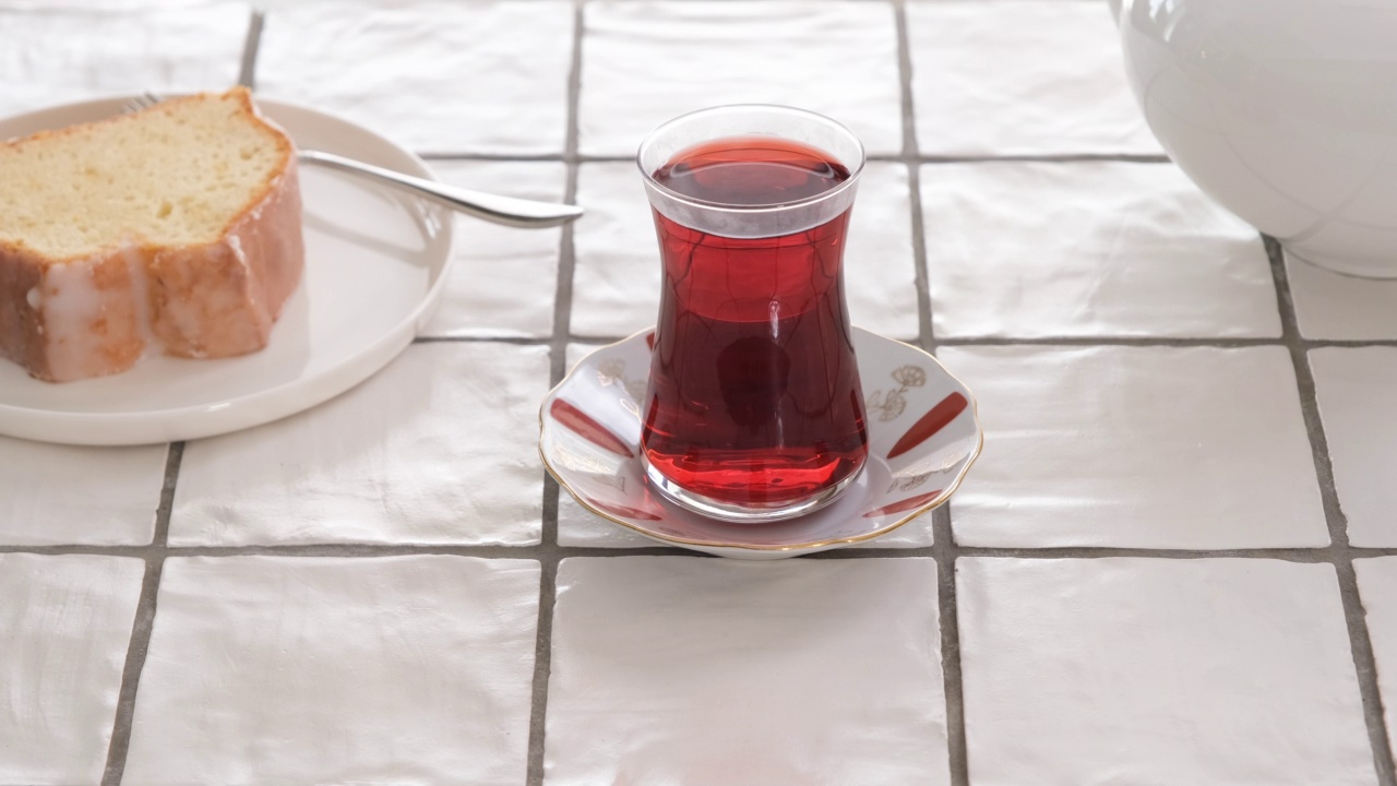 蒸汽从土耳其茶杯里冒出来，靠近，旁边有一块蛋糕，ib01视频素材
