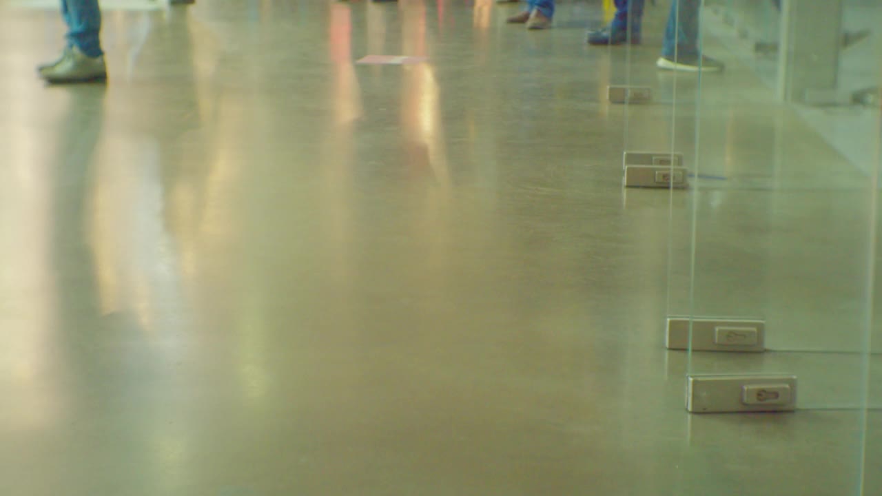 在商场里快速移动的购物者的腿。从较低的角度拍摄，特写视频下载