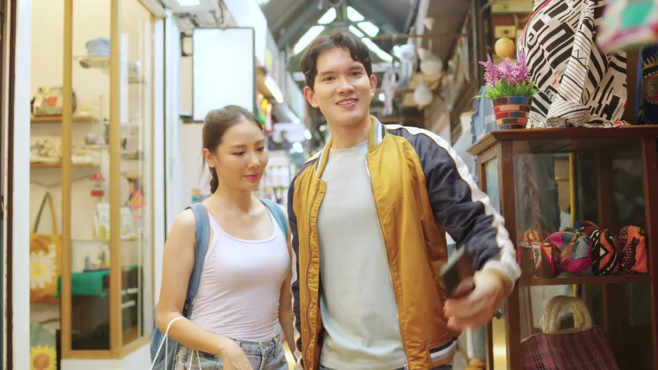 暑假期间，一对用手机一起在街市购物的4K亚洲情侣正在自拍。视频下载