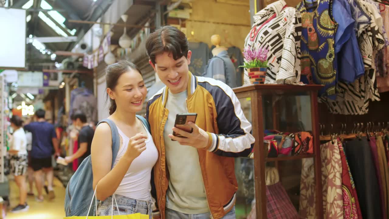 暑假期间，一对用手机一起在街市购物的4K亚洲情侣正在自拍。视频下载