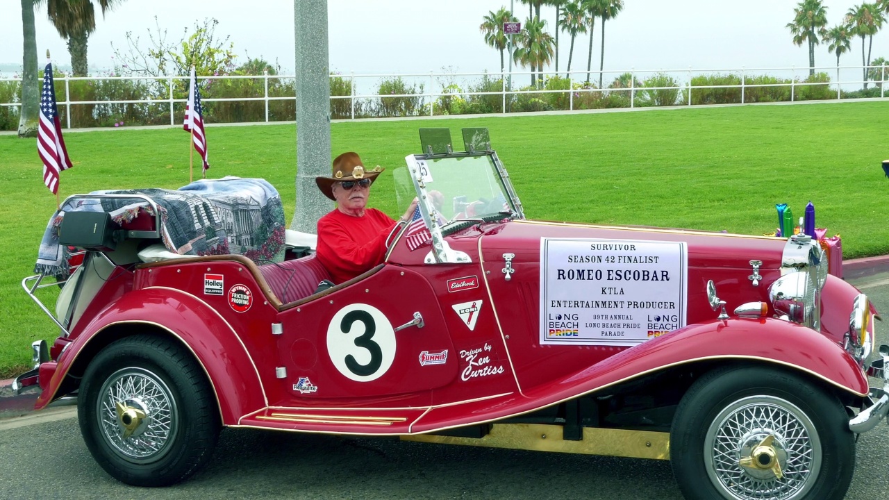 高级男子在帽子后面的红色经典老爷车的车轮在长滩，加利福尼亚州，4K视频下载