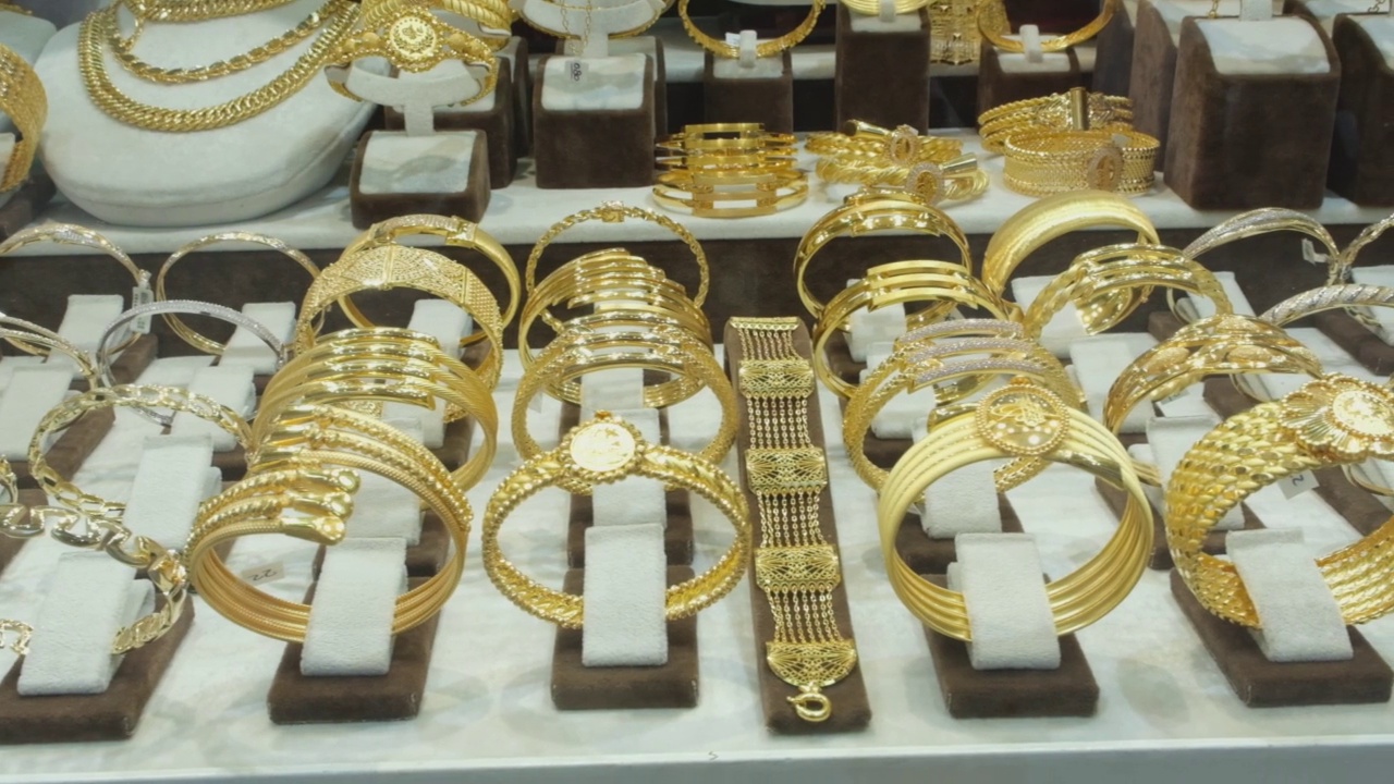 珠宝店出售的黄金首饰。精品陈列柜的黄金。商店橱窗里的金饰。视频下载