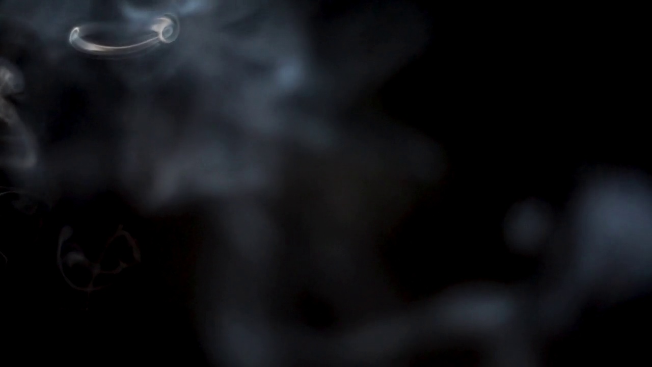 烟雾覆盖镜头覆盖背景的镜头。黑色背景上的浮动雾运动效果视频素材