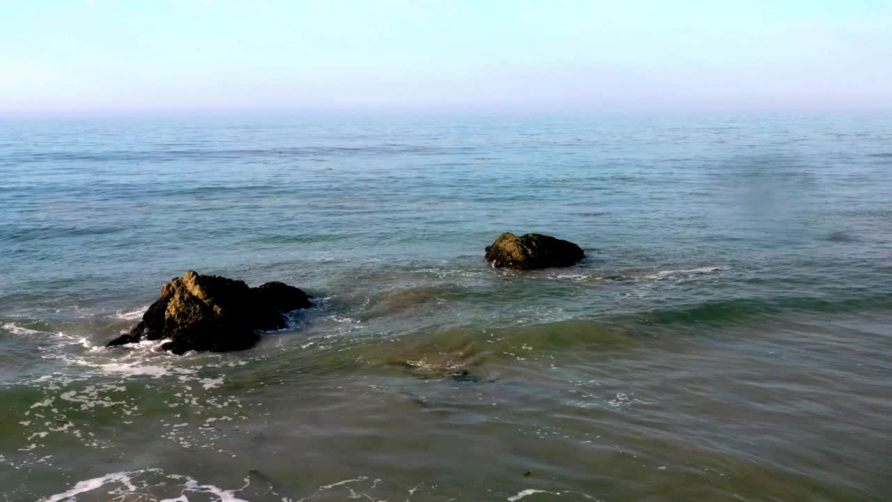 4K无人机库存视频的海滩马里布海滩北部的海浪撞在岩石上视频素材